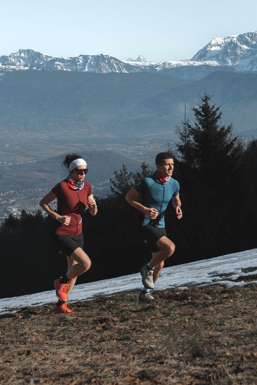 Maillot de trail porté par un homme et une femme en plein trail #couleur_ruby-wine #couleur_blue-legion