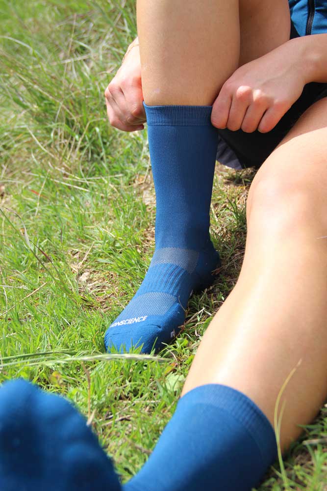 Chaussettes de running trail Bleu et Blanc pour femme, de face en extérieur par Caprin #couleur_bleu