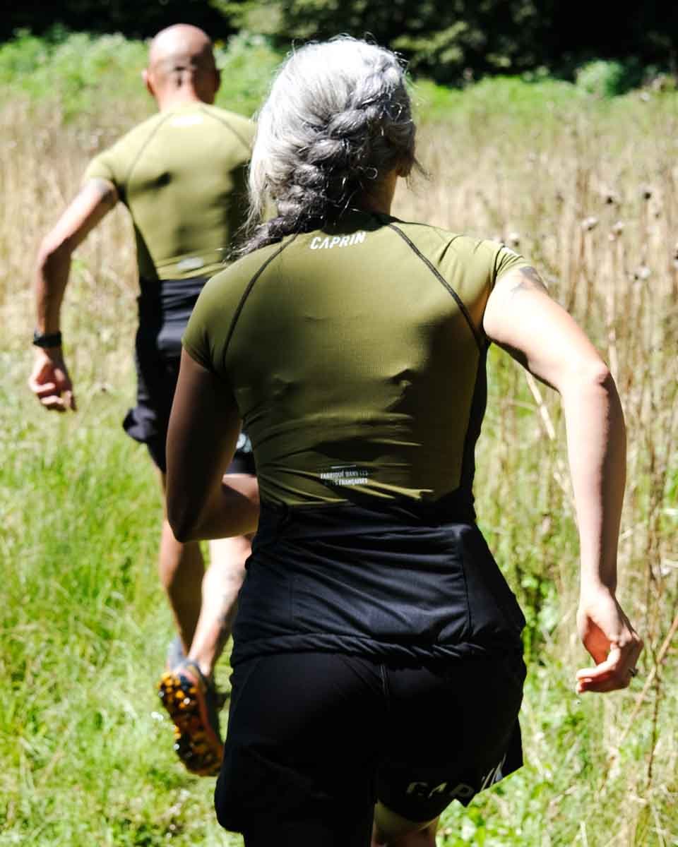 Maillot trail Caprin sport vert avocado portés par un homme et une femme en train de courir #couleur_vert-avocado