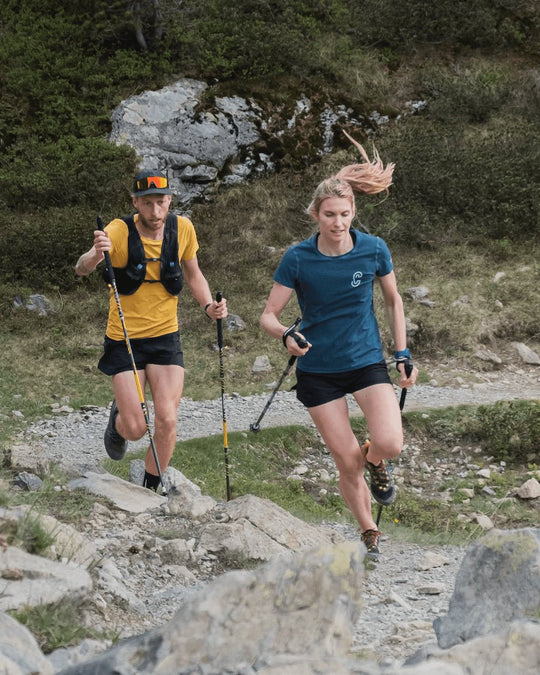 Short de running Maratrail porté par un homme et une femme en plein trail par Caprin