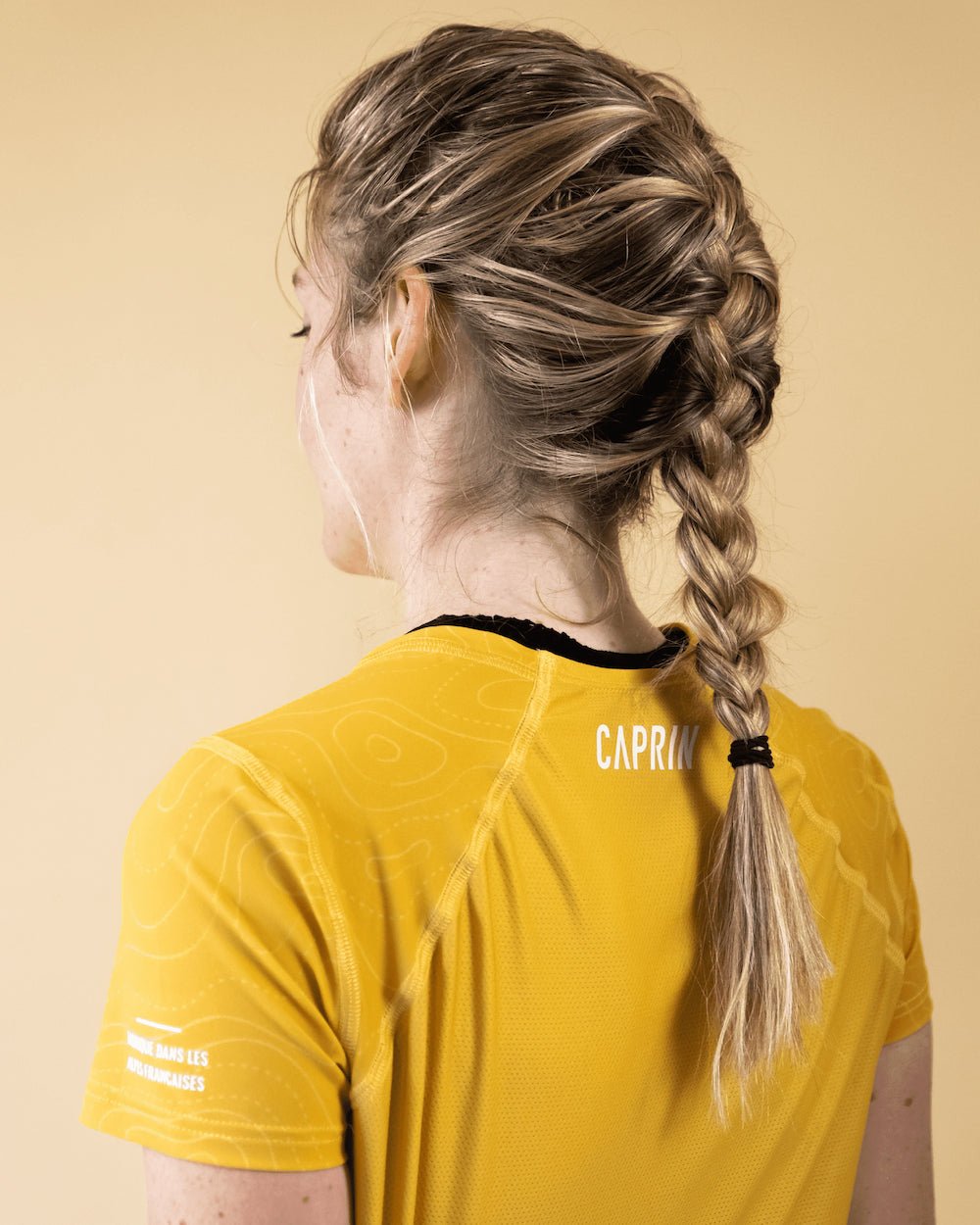 Femme portant le t-shirt de run Endorphine Caprin colori jaune de dos #couleur_yellow-stone