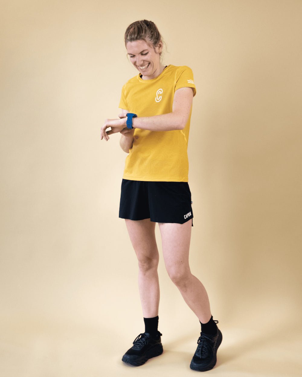Femme portant le t-shirt de run Endorphine Caprin colori jaune #couleur_yellow-stone